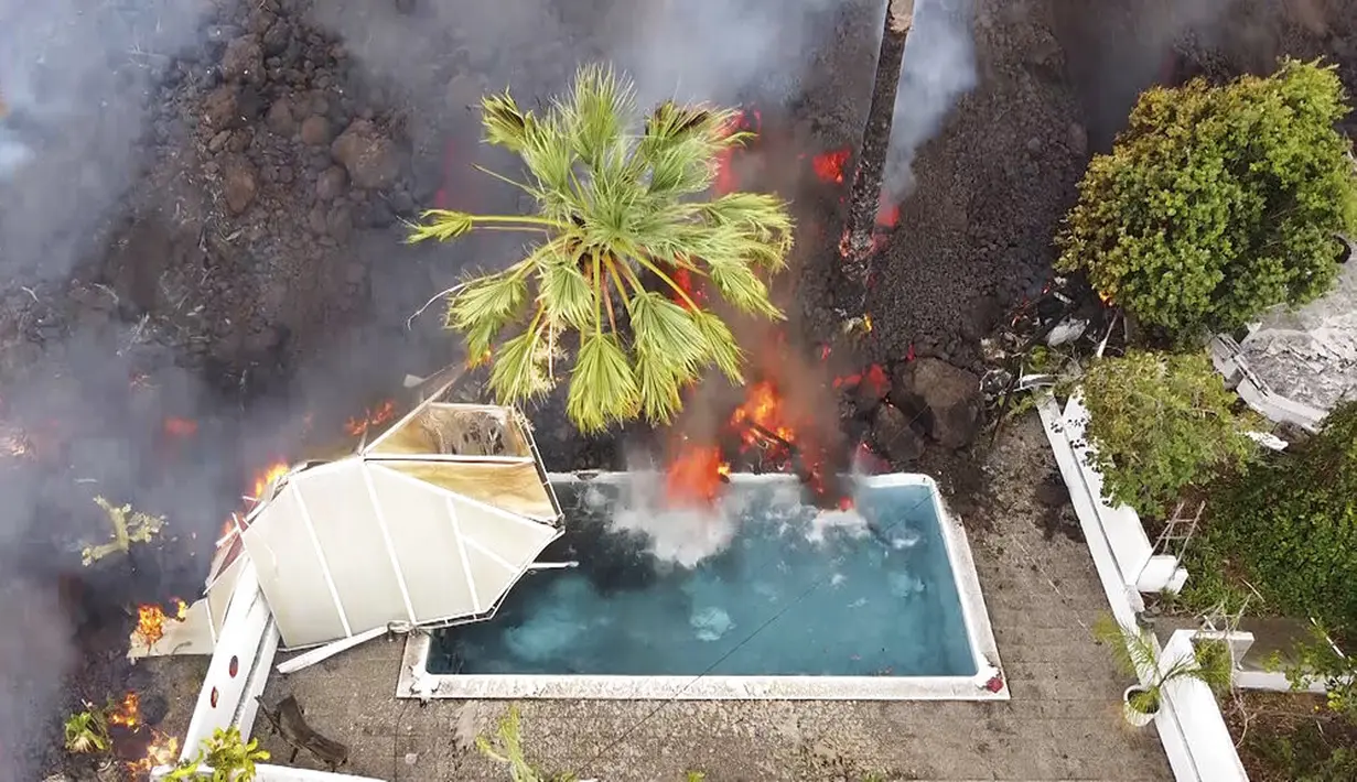 Lava panas mencapai kolam renang setelah letusan gunung berapi di pulau La Palma di Canaries, Spanyol (20/9/2021). Lava terus mengalir perlahan dari gunung berapi yang meletus di Canary Spanyol Kepulauan di barat laut Afrika. (Europa Press via AP)