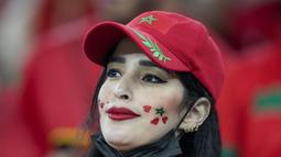 Fans wanita Maroko mengecat wajahnya jelang pertandingan grup F Piala Dunia 2022 antara Kanada dan Maroko di Stadion Al Thumama di Doha, Qatar, Kamis, 1 Desember 2022. (AP Photo/Frank Augstein)