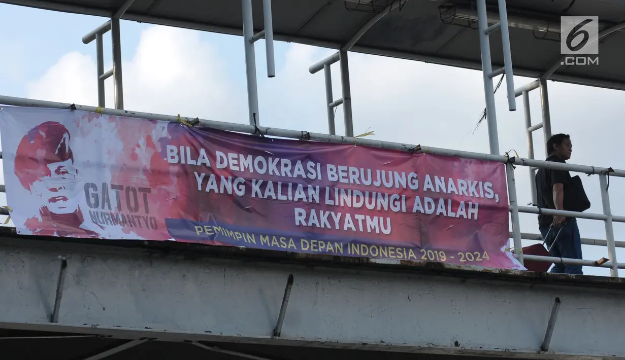 Warga melintas sisi spanduk dukungan untuk Gatot Nurmantyo di JPO Gambir Jalan Medan Merdeka Timur, Jakarta, Minggu (1/4). Terdapat tulisan "Pemimpin masa depan Indonesia 2019-2024,". (Liputan6.com/Helmi Fithriansyah)