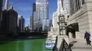 Orang-orang melihat Sungai Chicago yang berwarna hijau jelang Hari Santo Patrick di Chicago, Amerika Serikat, Sabtu (13/3/2021). Bahan yang digunakan untuk mewarnai Sungai Chicago dijamin tidak berbahaya bagi lingkungan. (Abel Uribe/Chicago Tribune via AP)