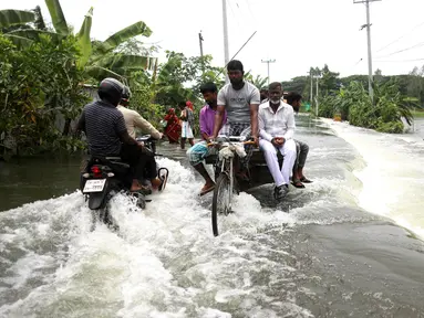 Warga melintasi jalan yang terendam banjir di Munshiganj, pinggiran Dhaka, Bangladesh, Senin (27/7/2020). Hingga 27 Juli 2020, hampir separuh dari wilayah Bangladesh masih terendam banjir. (Xinhua)