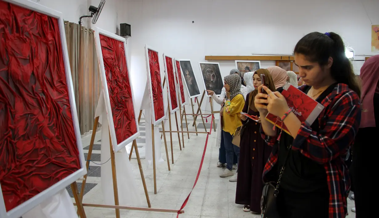 Orang-orang mengunjungi pameran seniman Palestina Kholoud al-Dasooqi di Gaza City, 11 Agustus 2020. Seniman Palestina asal Kota Khan Younis di Jalur Gaza itu menggelar pameran selama dua hari untuk mengungkap kekerasan terhadap perempuan melalui puluhan lukisan. (Xinhua/Rizek Abdeljawad)