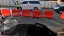 Seorang Polisi tampak mengatur lalu lintas agar tak macet di sekitar jalan yang amblas di kawasan Sudirman . Kamis (10/4/2014)  (Liputan6.com/Johan Tallo).