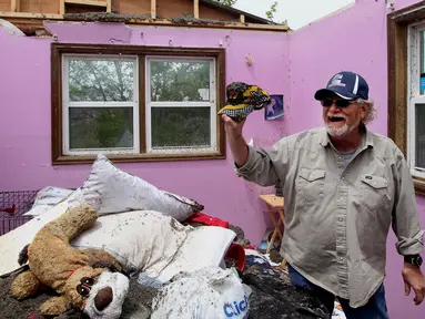 Seorang pria berada di rumanya yang rusak usai dilanda tornado di Laramie County, Wyoming, AS (29/5). Akibat tornado ini delapan properti dan rumah rusak berat. (Jacob Byk/The Wyoming Tribune Eagle via AP)