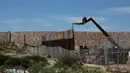 Alat berat memasang pagar pembatas yang merupakan bagian dari dinding perbatasan AS-Meksiko di Sunland Park, AS (09/9). Capres AS, Donald Trump berjanji akan membangun tembok yang kuat untuk menggantikan sekat pembatas. (REUTERS/Jose Luis Gonzalez)