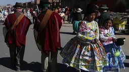 Gadis-gadis mengenakan kostum yang terbuat dari kantong plastik susu saat memeriahkan di Bolivia, Selasa (14/8). Siswa sekolah San Roque membuat kostum dari bahan daur ulang untuk meningkatkan kesadaran pengelolaan limbah padat. (AP/Juan Karita)