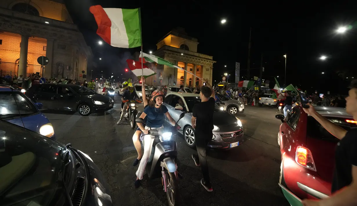 Suporter merayakan kemenangan Italia atas Inggris pada pertandingan final Euro 2020 di Milan, Italia, Senin (12/7/2021). Italia menjuarai Euro 2020 usai mengalahkan Inggris lewat drama adu penalti pada pertandingan final. (AP Photo/Luca Bruno)
