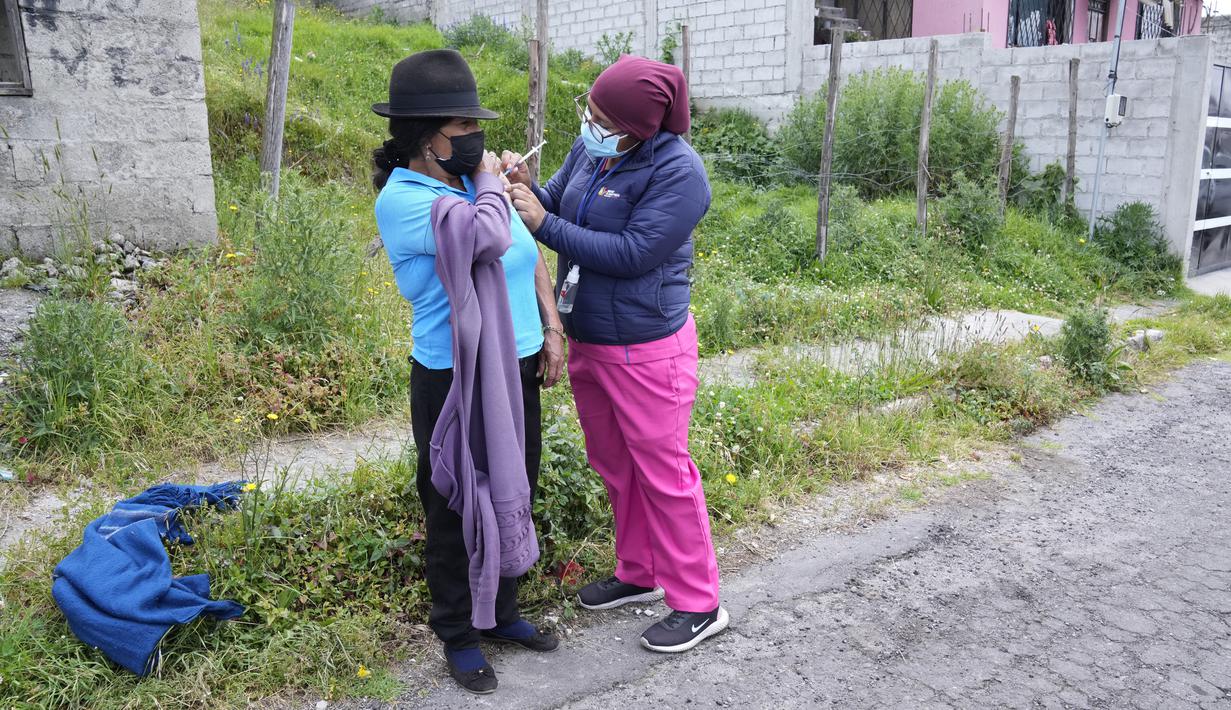 Petugas kesehatan memvaksinasi seorang wanita di sebuah jalan di lingkungan Lucha de los Pobres, Ekuador, 26 Januari 2022. Brigade campuran dari pemerintah kota dan Kementerian Kesehatan mengunjungi lingkungan miskin untuk mendeteksi kasus COVID-19 dan melakukan vaksinasi. (AP Photo/Dolores Ochoa)