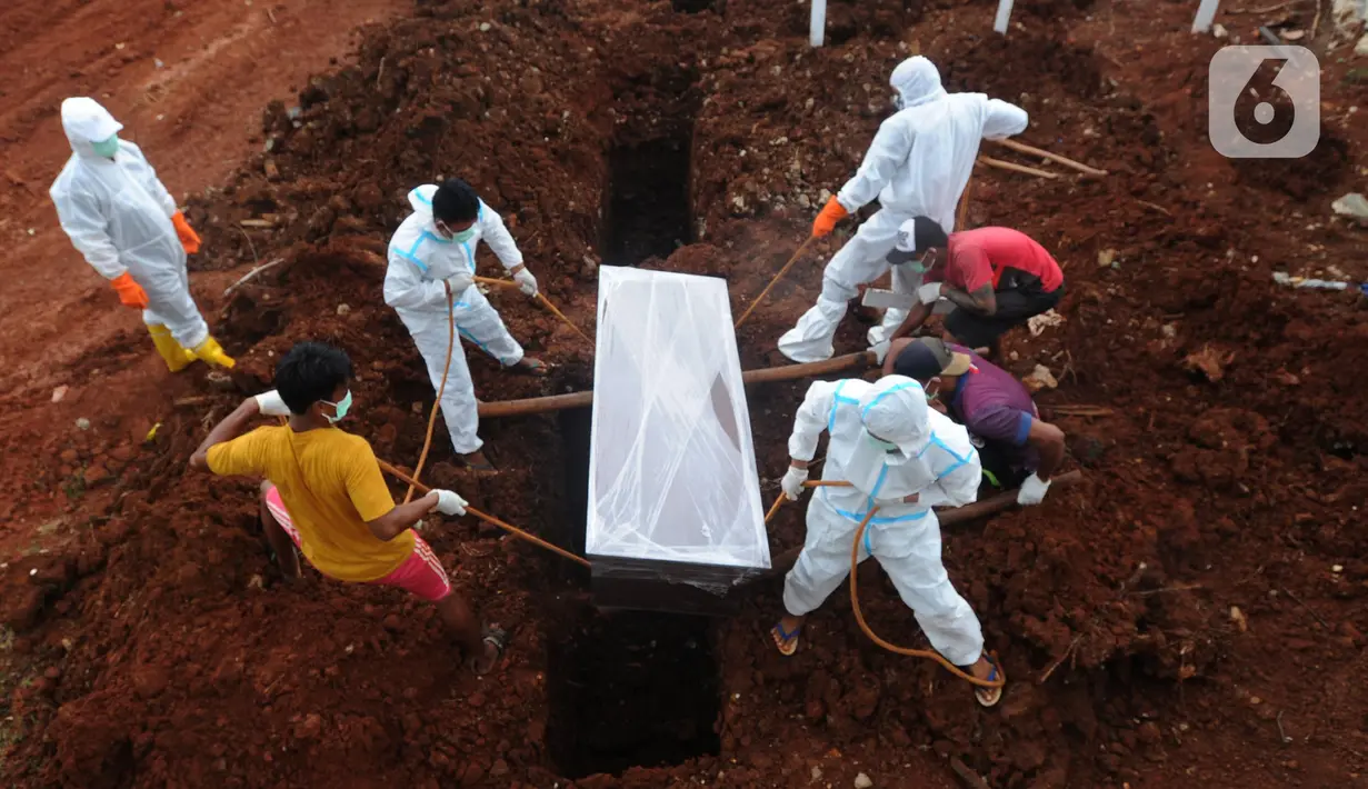 Petugas melakukan pemakaman korban COVID-19 di TPU Jombang, Tangerang Selatan, Banten, Senin (18/1/2021). Sudah dua minggu terakhir terjadi penambahan pemakaman korban COVID-19 di TPU Jombang. (merdeka.com/Arie Basuki)