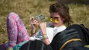 Seorang wanita bersantai saat menghadiri Festival Musik Glastonbury di Worthy Farm, di Somerset, Inggris, (22/6). Glastonbury Festival 2017 dimulai 21 Juni-26 Juni dengan penonton berjumlah ratusan ribu orang. (AFP Photo/Oli Scarff)