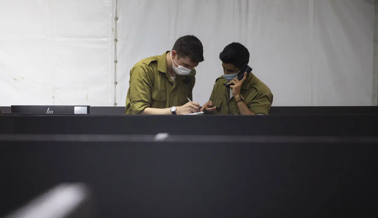 Tentara mewawancarai seseorang yang terinfeksi COVID-19 untuk mengidentifikasi dengan siapa orang tersebut telah berhubungan di Markas Home Front Command, Ramle, Israel, 25 Agustus 2020. Israel mengerahkan tentara untuk membantu menghadapi pandemi COVID-19. (AP Photo/Sebastian Scheiner)