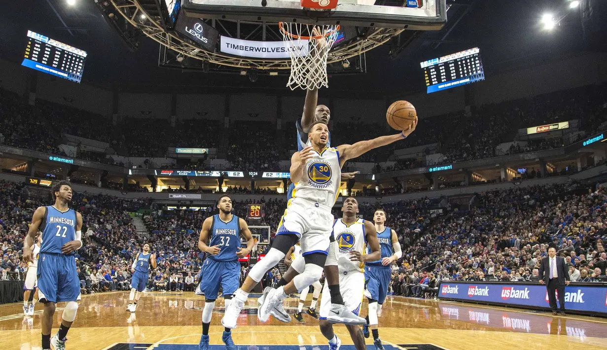 Pemain Golden State Warriors, Stephen Curry #30 mencoba memasukan bola kedalam keranjang saat dihadang pemain Wolves, Gorgui Dieng #5 pada laga NBA di Target Center. Warriors menang 116-108. (Reuters/Jesse Johnson-USA TODAY Sports)