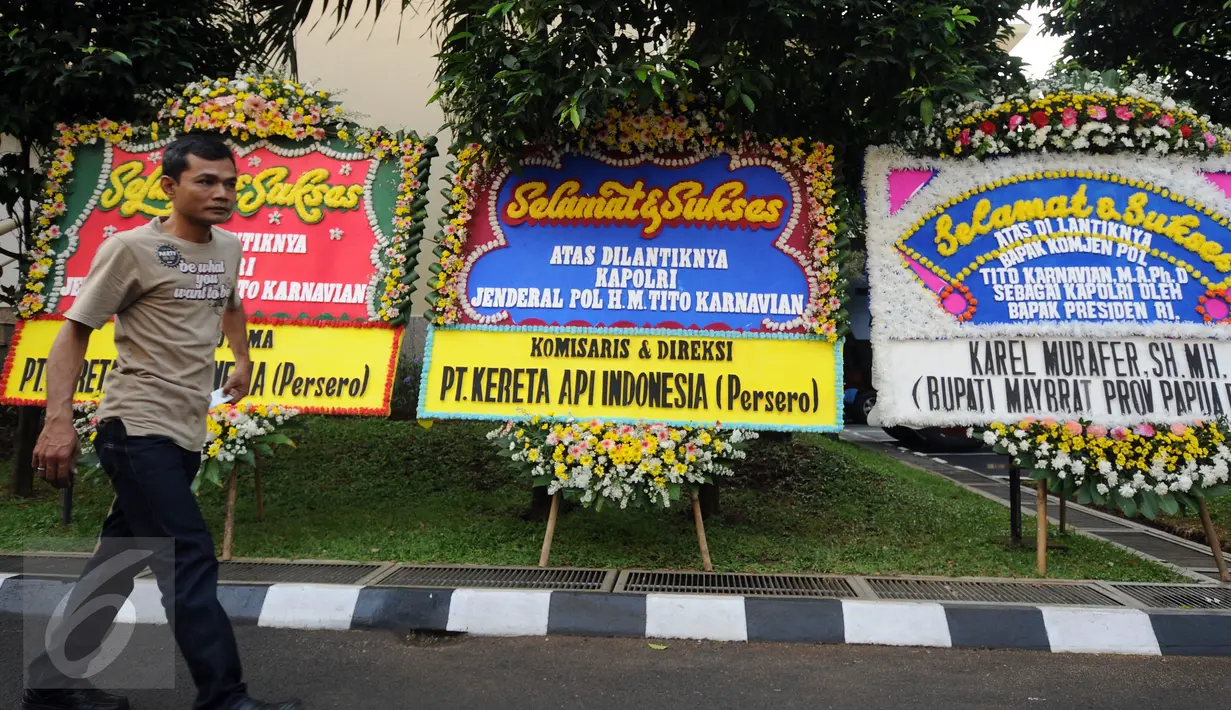 Pekerja melintas di depan karangan bunga ucapan selamat dilantiknya Komjen Pol Tito Karnavian di Mabes Polri, Jakarta, Rabu (13/7). Tito Karnavian akan dilantik menjadi Kapolri di Istana Negara oleh Presiden Jokowi. (Liputan6.com/Helmi Fithriansyah)