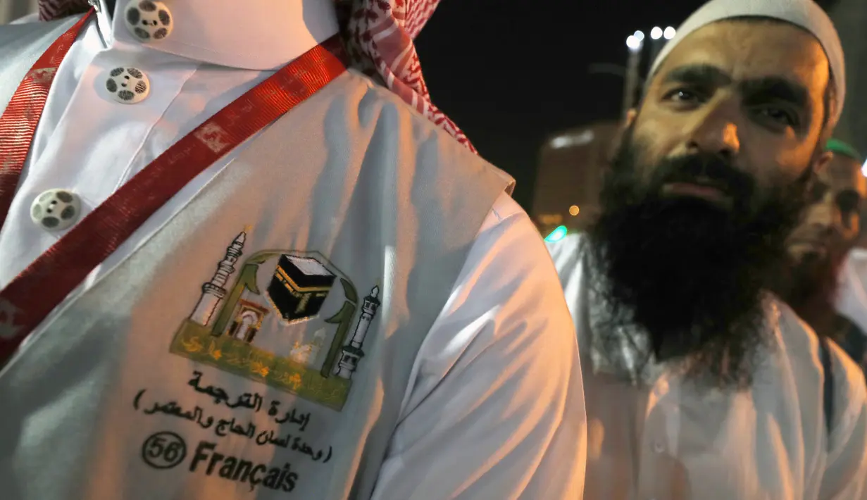 Seorang penerjemah menunggu untuk membantu jemaah haji di kota suci Makkah, Arab Saudi, 17 Agustus 2018. Para penerjemah ini bisa dicirikan dengan pria yang memakai rompi abu-abu, dan di dadanya dibordir nama bahasa yang dikuasai. (AFP/AHMAD AL-RUBAYE)