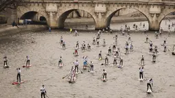 Peserta mendayung melewati aliran sunga- sungai selama perlombaan dayung dan perahu di Sungai Seine di Paris, Perancis, Minggu, (2/12). Peserta akan mendayung sejauh 10 km. (AFP)