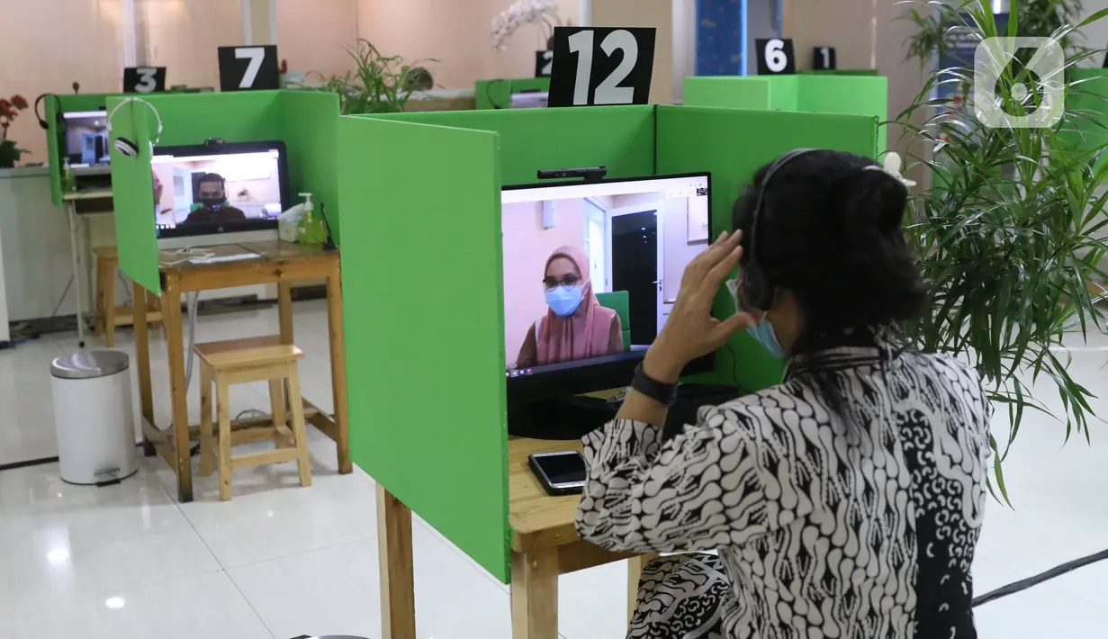 Petugas dari LAPAK ASIK (Layanan Tanpa Kontak Fisik) melayani peserta BPJAMSOSTEK di Kantor Cabang Tangerang, Jumat (12/6/2020). Layanan dengan protokol kesehatan tanpa harus kontak langsung ini untuk mencegah penularan COVID-19 di masa tatanan normal baru. (Liputan6.com/Angga Yuniar)