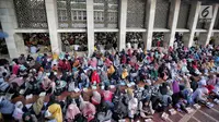 Umat muslim menunggu azan magrib saat mengikuti buka puasa bersama di Masjid Istiqlal, Jakarta, Senin (6/5/2019). Banyaknya umat muslim yang datang menyebabkan sebagian di antaranya harus duduk di luar mesjid. (Liputan6.com/Faizal Fanani)