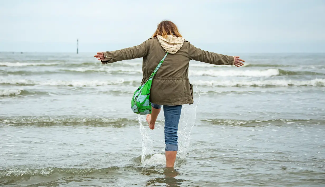 Seorang wanita menikmati suasana laut dan pantai di Dunkirk, Prancis (16/5/2020). Disertai langkah-langkah pencegahan seperti menjaga jarak sosial, sejumlah pantai di Prancis utara dibuka kembali mulai Sabtu (16/5) setelah pelonggaran lockdown akibat merebaknya COVID-19. (Xinhua/Sebastien Courdji)