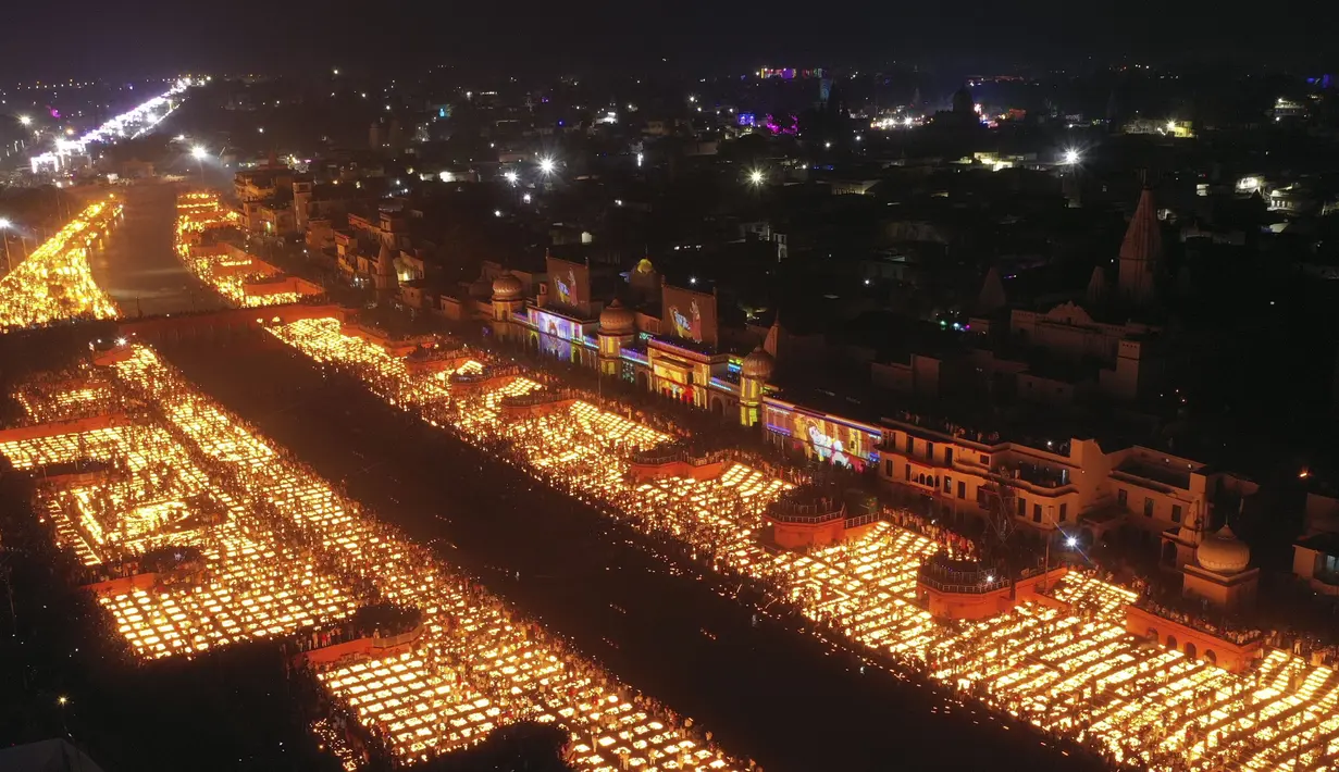 Orang-orang menyalakan lampu di tepi sungai Saryu di Ayodhya, India, Rabu (3/11/2021). Lebih dari 900.000 lampu minyak dinyalakan dan terus menyala selama 45 menit saat kota Ayodhya mempertahankan Rekor Dunia Guinness sebagai bagian dari perayaan festival Diwali. (AP Photo/Rajesh Kumar Singh)