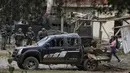 Seorang wanita berjalan di samping reruntuhan bom mobil yang meledak di depan kantor polisi di Timba, Cauca, Kolombia, Minggu, 13 Agustus 2023.  (AP Photo/Andres Quintero)