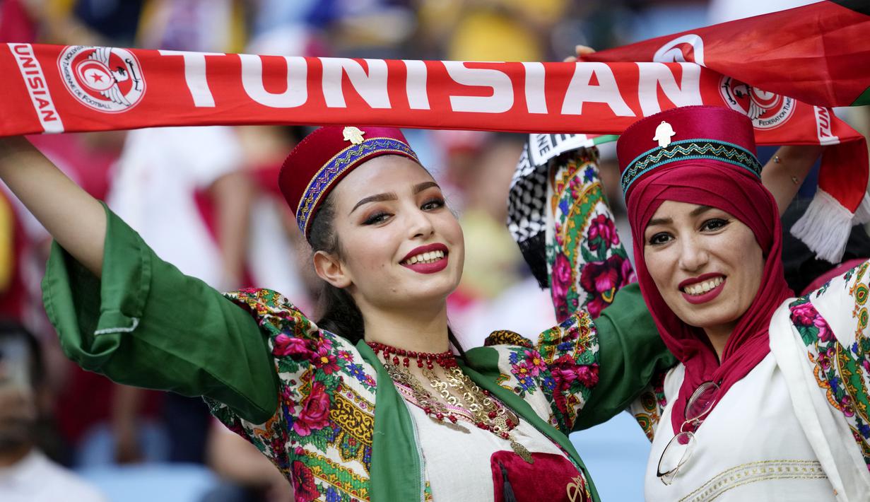 Suporter wanita Tunisia berpose saat menghadiri pertandingan melawan Australia pada laga Piala Dunia di Stadion Al Janoub, Qatar, Sabtu (26/11/2022). (AP/Luca Bruno)