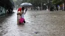 Orang-orang menyeberang jalan melintasi banjir saat hujan lebat di Mumbai, India, Rabu, (5/8/2020). Musim hujan India berlangsung dari Juni hingga September. (AP Photo/Rajanish Kakade)