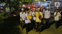Umat muslim memainkan rebana saat yang lainnya membawa obor sambil berkeliling kampung di kawasan Kota Tangerang, Banten, Jumat (29/7/2022) malam. Pawai obor tersebut digelar untuk menyambut malam pergantian Tahun Baru Islam atau 1 Muharam 1444 H. (Liputan6.com/Angga Yuniar)