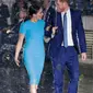 Pangeran Harry dan Meghan Markle sepayung berdua saat tiba di Endeavour Fund Awards, London, Inggris, Kamis (5/3/2020). Hujan lebat turun saat Pangeran Harry dan Meghan Markle tiba di lokasi. (AP Photo/Kirsty Wigglesworth)