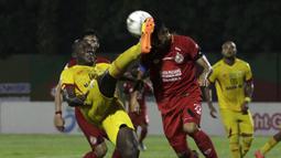 Striker Bhayangkara FC, Herman Dzumafo, berebut bola dengan bek Semen Padang, Dedy Gusmawan, pada laga Shopee Liga 1 di Stadion PTIK, Jakarta, Sabtu (2/11). Bhayangkara bermain imbang 2-2 atas Semen Padang. (Bola.com/Yoppy Renato)