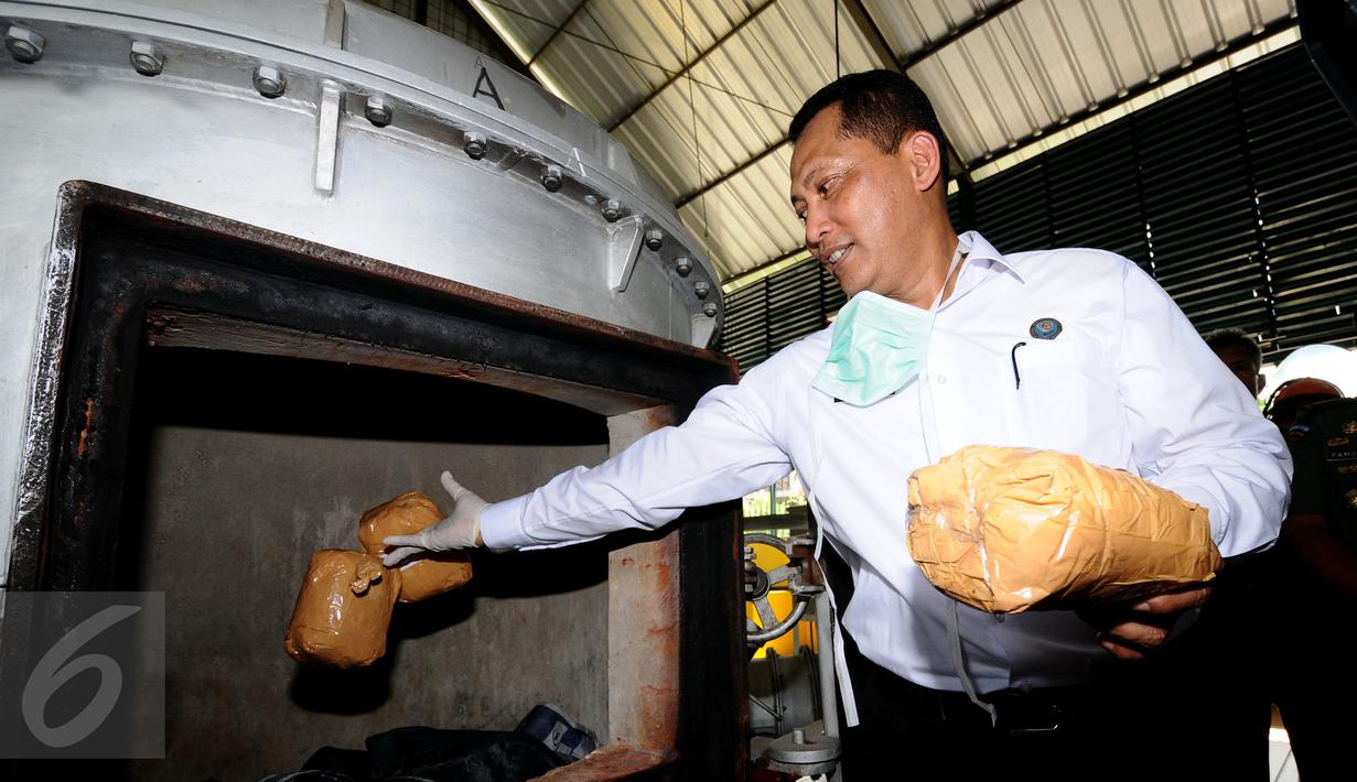 Kepala BNN, Komjen Pol Budi Waseso memasukkan barang bukti ganja yang akan dimusnahkan ke dalam insenerator RSPAD, Jakarta, Rabu (7/9). Barang bukti yang dimusnahkan 173, 318 Kg sabu dan 2.851,887 gram ganja. (Liputan6.com/Helmi Fithriansyah)