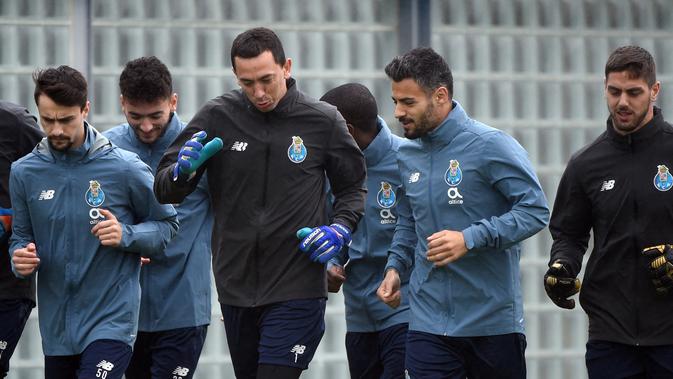 Penjaga gawang FC Porto Agustin Marchesin (tengah) melakukan pemanasan bersama rekan satu tim selama sesi latihan di tempat latihan Olival di Vila Nova de Gaia (16/2/2021). Porto merupakan penghuni peringkat kedua Grup C Liga Champions. (AFP/Miguel Riopa)