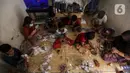 Anak-anak membuat serokan ikan cupang di rumah kontrakan Udin, Sukabumi Selatan, Jakarta Barat, Selasa (22/12/2020). Dalam sehari, Udin sanggup membuat serokan ikan cupang sebanyak 400 buah. (Liputan6.com/Johan Tallo)