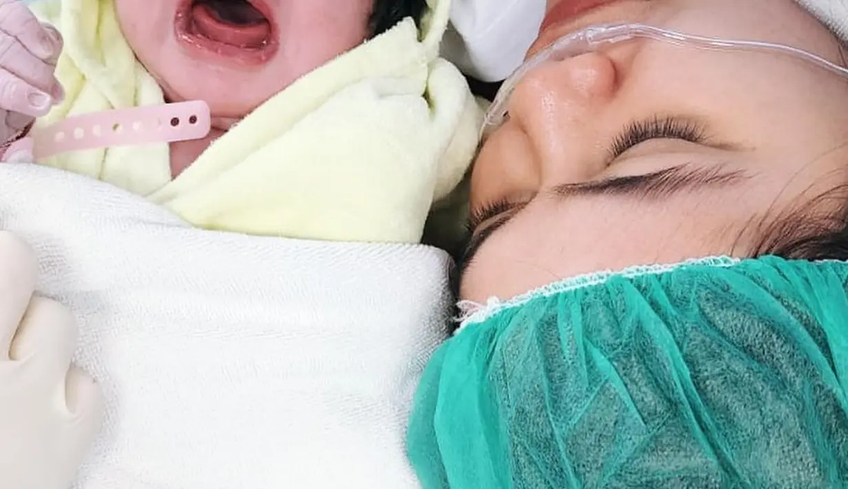 Pemeran Kinanti dalam sinetron Dewi Rindu itu juga menutup wajah Baby D dengan stiker. Begitu juga potret kedua yang hanya terlihat separuh. Dan kemudian ada satu potret lagi telapak kaki anaknya. [Instagram/indahindriana]