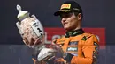 Pembalap McLaren, Lando Norris melihat trofi juara saat merayakan kemenangan dalam ajang balap Formula 1 GP Hungaria 2025 di sirkuit Hongaroring, Minggu (03/08/2025) waktu setempat. (AP Photo/Denes Erdos)