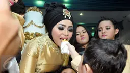 Muzdalifah tampak disuapi potongan kue oleh sang anak saat perayaan ulang tahunnya yang ke-37 tahun di kawasan Pramuka, Jakarta Timur, Senin (15/6/2015). (Liputan6.com/Panji Diksana)