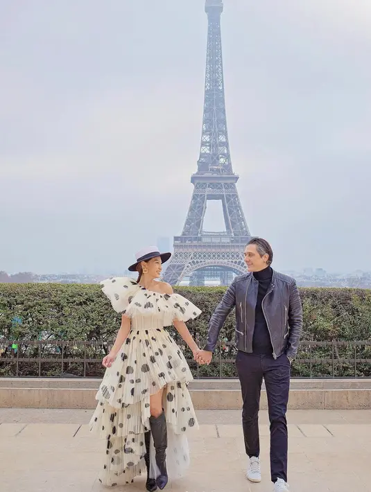 Tampil dengan gaun asimetris, potret Patricia Gouw di Paris dengan sang suami tampak super stylish. [Foto: Instagram/ carolinaphoto_paris]