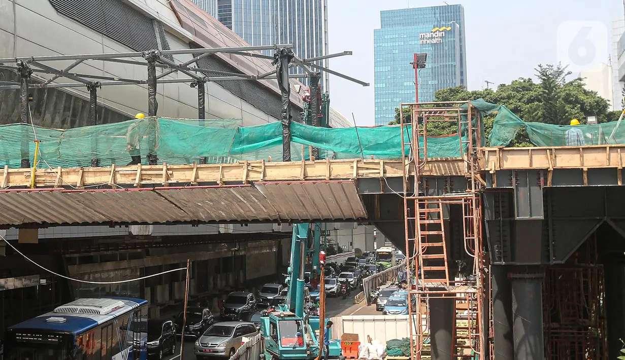 Pekerja menyelesaikan pembangunan JPO Stasiun LRT Rasuna Said di Jakarta, Senin (11/7/2022). Jadwal uji coba LRT Jabodebek batal dilakukan pada 17 Agustus 2022 dan direncakanan digelar pada Desember 2022 karena adanya kendala dalam skema pembiayaan pembangunan LRT Jabodebek. (Liputan6.com/Faizal Fanani)