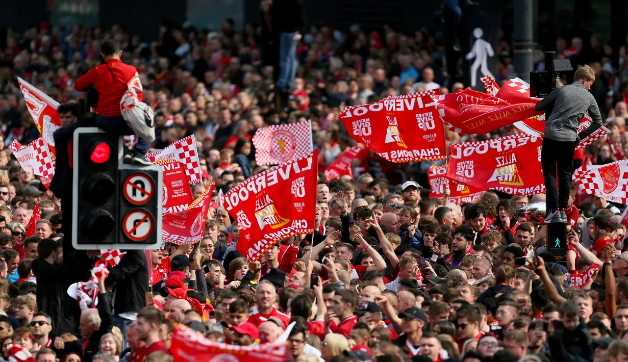 Suporter menyambut kedatangan pemain Liverpool saat parade juara Liga Champions di Liverpool, Inggris (2/6/2019). Ribuan suporter tumpah ruah di jalanan merayakan kemenangan tim kesayangannya meraih piala Liga Champions usai mengalahkan Tottenham di final dengan skor 2-0. (Richard Sellers/PA via AP)