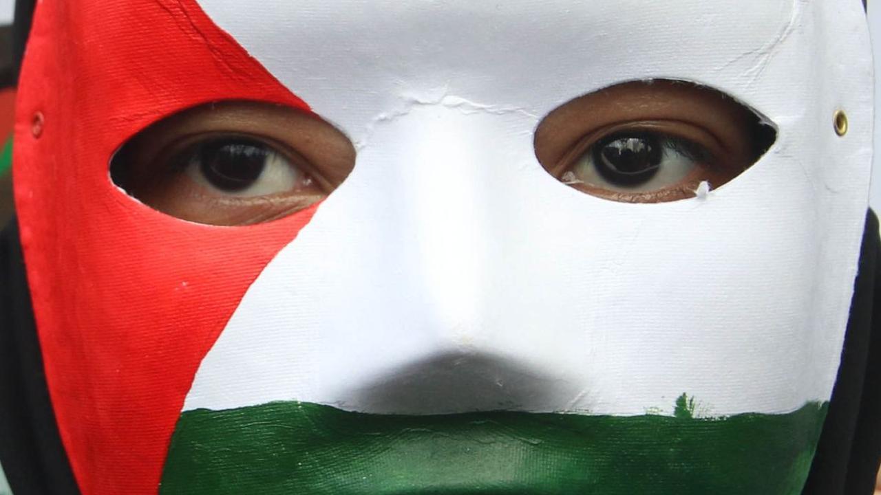 Seorang peserta memakai masker dengan warna bendera Palestina saat menghadiri Aksi Bela Palestina di depan Kantor Kedubes AS, Jakarta, Sabtu (13/1/2024).