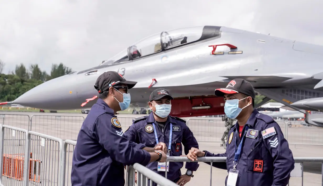 Personel Angkatan Udara Diraja Malaysia mengenakan masker di area static aircraft display selama Singapore Airshow di Singapura, Selasa (11/2/2020). Air show tersebut dibayangi wabah virus korona, yang memaksa puluhan perusahaan dunia absen dalam perhelatan besar itu. (AP/Danial Hakim)