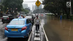 Suasana kawasan Gambir yang direndam banjir di Jakarta, Kamis (15/2). Banjir tersebut mengakibatkan jalan di sekitar lokasi terpaksa ditutup karena tidak bisa dilalui kendaraan bermotor. (Liputan6.com/Immanuel Antonius)