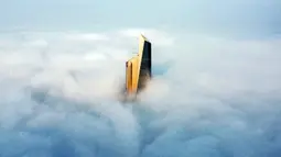 Pemandangan udara memperlihatkan puncak Al Hamra Tower di antara kabut tebal, Kuwait City, 23 Januari 2023. Al Hamra Tower digunakan sebagai kantor dan sekitar empat lantai untuk mal. (YASSER AL-ZAYYAT/AFP)