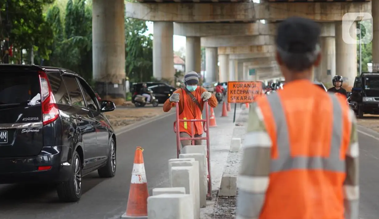 Pekerja menyelesaikan pembuatan separator atau pembatas jalan di Jalan Margasatwa, Andara, Jakarta Selatan, Kamis (21/11/2019). Separator itu dibuat guna memisahkan dua lajur sehingga meminimalisasi tingkat kecelakaan. (Liputan6.com/Immanuel Antonius)
