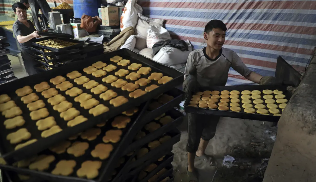 Seorang tukang roti memasukkan penganan manis ke dalam oven di toko roti tradisional menjelang bulan puasa Ramadan mendatang, di Kabul, Afghanistan, pada 7 April 2021. Sebentar lagi, umat Muslim di seluruh dunia akan menyambut bulan Ramadan.  (AP Photo / Rahmat Gul)