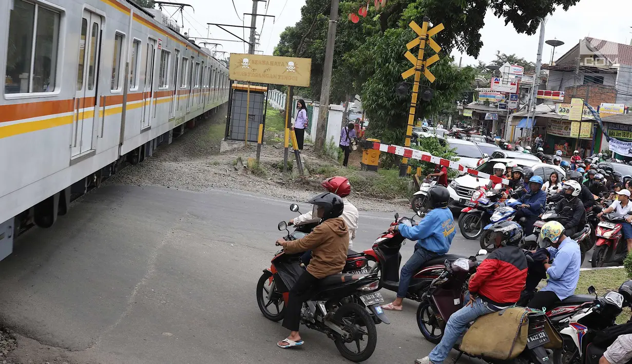 Kereta melintas di kawasan Lenteng Agung, Jakarta, Selasa (13/3). Untuk mengurai kemacetan imbas antrian kendaraan berputar balik di pintu kereta IISIP, Pemprov DKI berencana membangun flyover U-Turn di kawasan tersebut. (Liputan6.com/Immanuel Antonius)