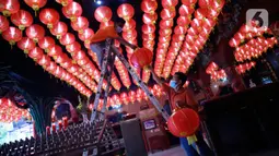 Pekerja memasang lampion pemberian umat di Klenteng Boen San Bio, Tangerang, Kamis (28/1/2021). Sebanyak 800  lampion dipasang untuk mempercantik Klenteng jelang perayaan Tahun Baru Imlek. (Liputan6.com/Angga Yuniar)