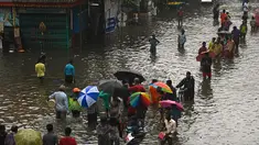 Orang-orang mengarungi jalan yang banjir setelah hujan lebat di Chennai, India (8/11/2021). Chennai dilanda Curah Hujan Terberat Sejak 2015,  Pihak berwenang Keluarkan Peringatan Banjir. (AFP/Arun Sankar)