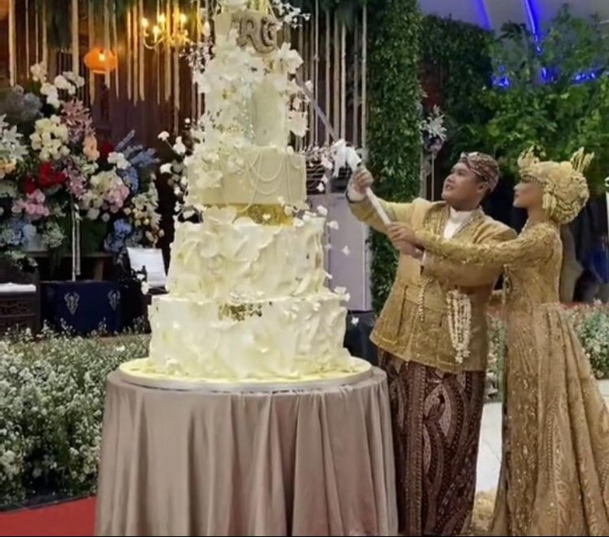 Inilah potret mempelai bernama Radja dan Galuh saat sedang melakukan sesi potong kue pernikahan secara simbolis.&nbsp;