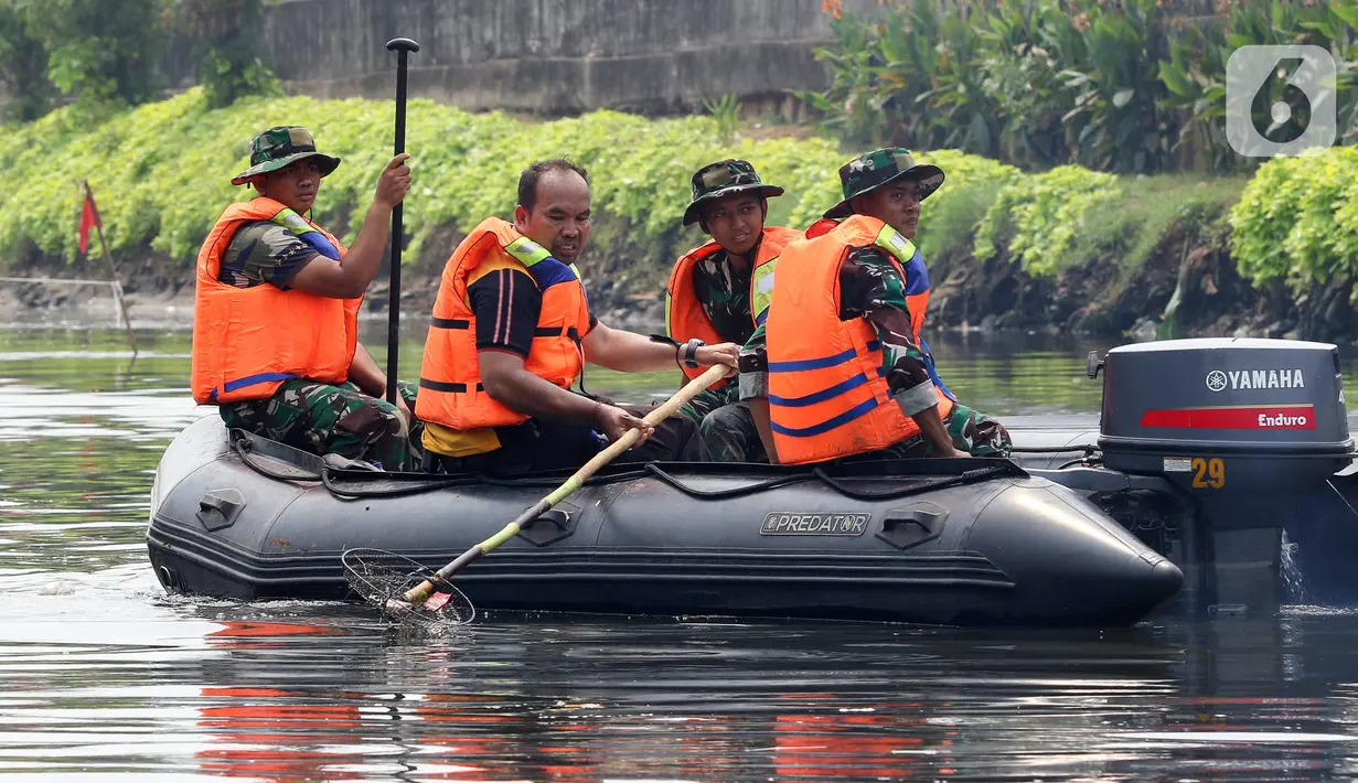 Personel TNI membersihkan sampah saat kegiatan Grebeg Kali Ciliwung. (Liputan6.com/Herman Zakharia)