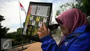 Mahasiswi mencoba peralatan kotak lubang jarum yang akan di gunakan untuk mengamati gerhana matahari di taman Pintar Yogyakarta, (2/3). Kawasan Tugu menjadi salah satu tempat pengamatan gerhana matahari pada 9 Maret 2016. (Liputan6.com/Boy Harjanto)